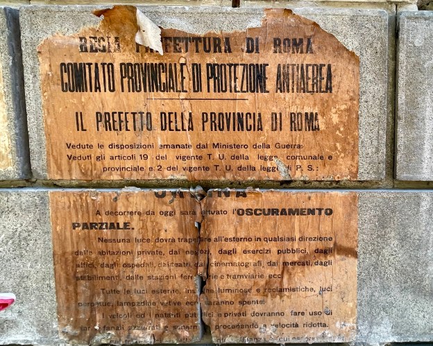 Manifesto (A) in Via Cola di Rienzo a Roma, post 1940. (Foto SAM). Avviso ufficiale della Regia Prefettura di Roma sull’oscuramento antiaereo della città, affisso dopo l’entrata in guerra dell’Italia nel 1940. Rimasto nascosto per oltre cinquant’anni sotto le vetrine del negozio Dickinson in Via Cola di Rienzo. Diritti foto M.I. Safarik, 17 maggio 2026